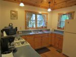 A bright and cheery kitchen with plenty of countertop space, supplies, and full sized appiances